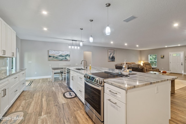 kitchen with stainless steel electric range, white cabinetry, and a large island