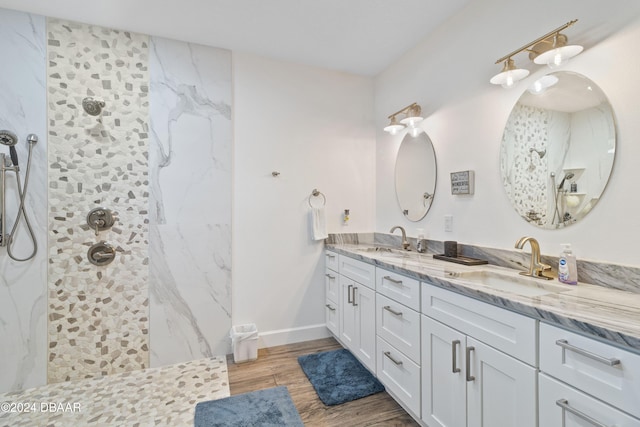 bathroom featuring tiled shower, wood-type flooring, and vanity