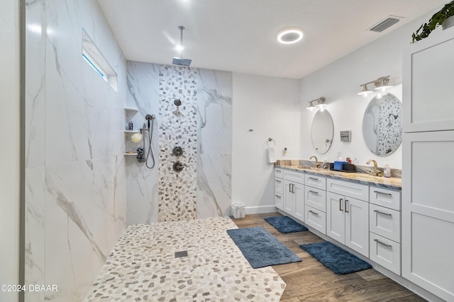 bathroom with vanity, hardwood / wood-style flooring, and a tile shower