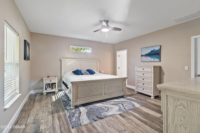 bedroom featuring a textured ceiling, ceiling fan, and light hardwood / wood-style flooring