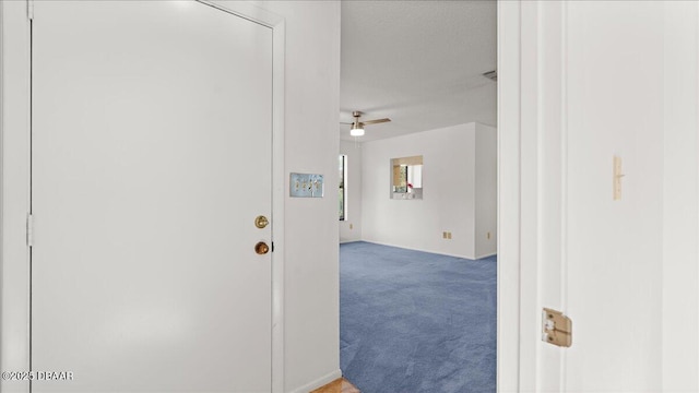 corridor with carpet flooring and a textured ceiling