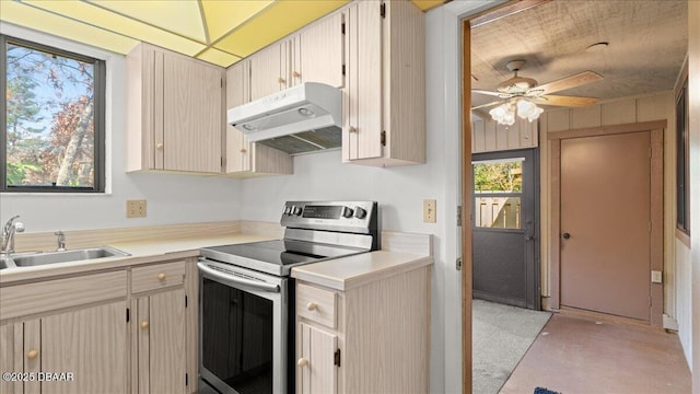 kitchen with stainless steel electric range oven, sink, ceiling fan, and light brown cabinetry