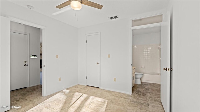 unfurnished bedroom with ceiling fan, ensuite bathroom, and a closet