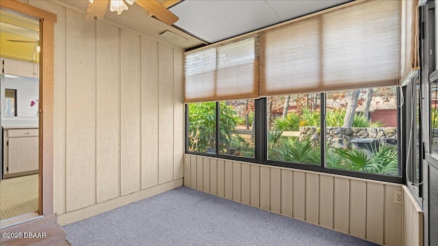 unfurnished sunroom with ceiling fan