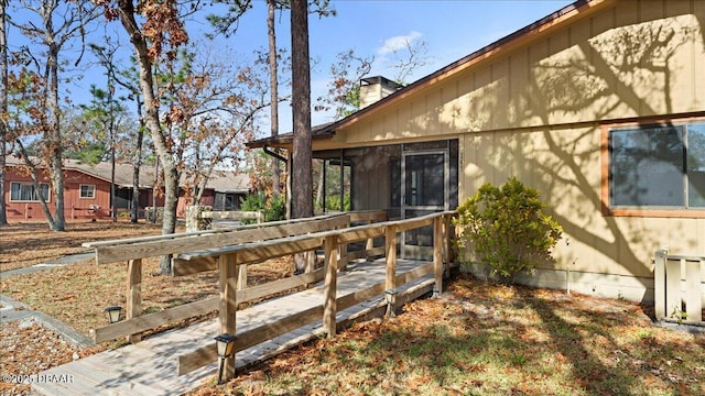 view of side of property featuring a deck and a sunroom