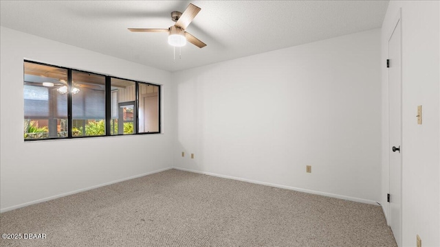 carpeted spare room with a textured ceiling and ceiling fan