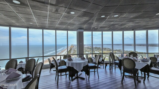 dining room featuring a wealth of natural light, a water view, and floor to ceiling windows