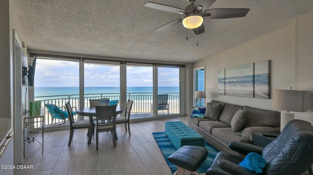 sunroom with plenty of natural light, ceiling fan, and a water view