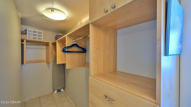 spacious closet with light tile patterned floors