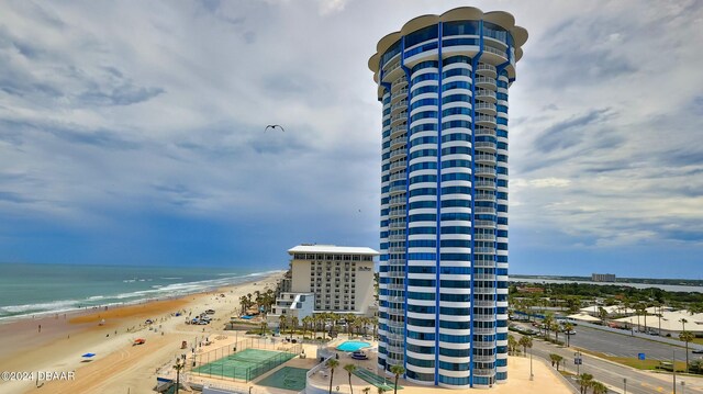 view of property with a water view and a beach view