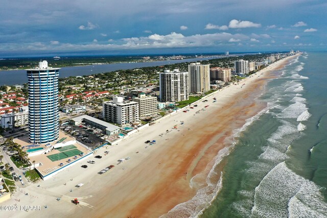 birds eye view of property with a water view and a beach view