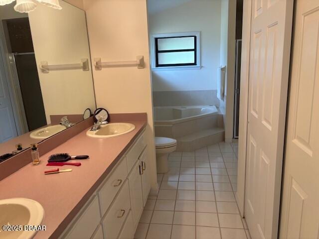 bathroom with tile patterned floors, toilet, vanity, and a tub