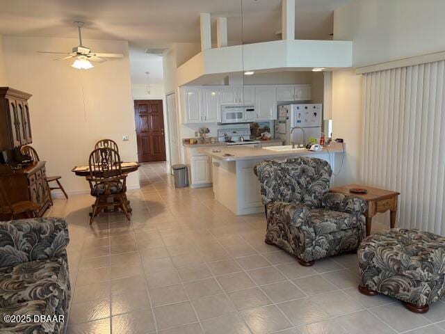 tiled living room featuring a towering ceiling and ceiling fan