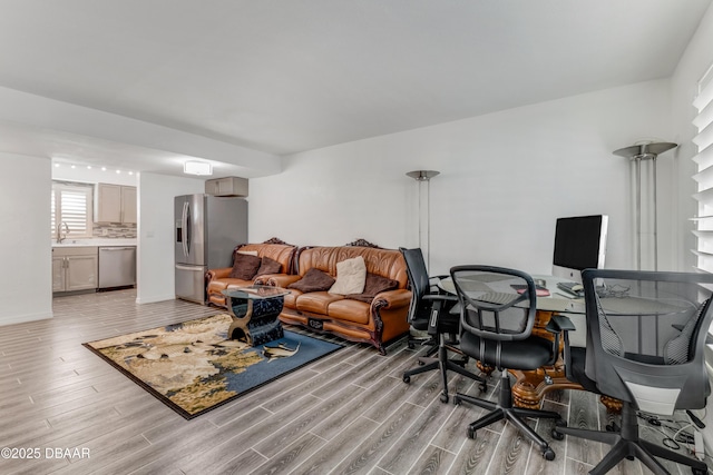 living room with light hardwood / wood-style floors and sink