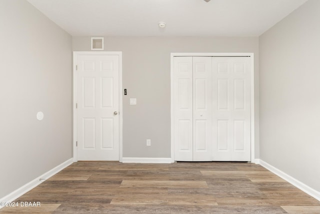 unfurnished bedroom featuring hardwood / wood-style floors and a closet