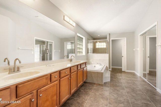 bathroom with lofted ceiling, tile patterned floors, a textured ceiling, plus walk in shower, and vanity