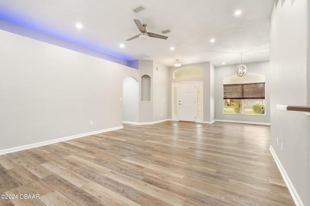 unfurnished living room with light hardwood / wood-style floors and ceiling fan with notable chandelier