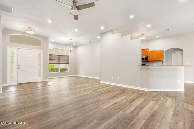 unfurnished living room featuring ceiling fan and light hardwood / wood-style flooring