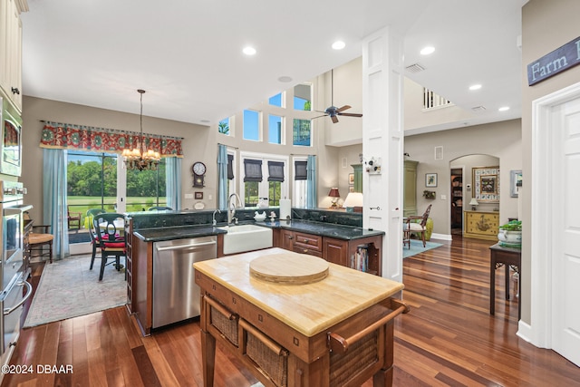 kitchen featuring stainless steel appliances, hanging light fixtures, dark wood-type flooring, and kitchen peninsula