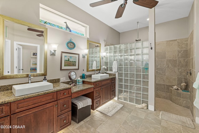 bathroom with ceiling fan, vanity, and a tile shower