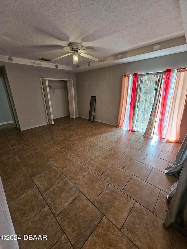 unfurnished bedroom featuring a textured ceiling, ceiling fan, and a closet