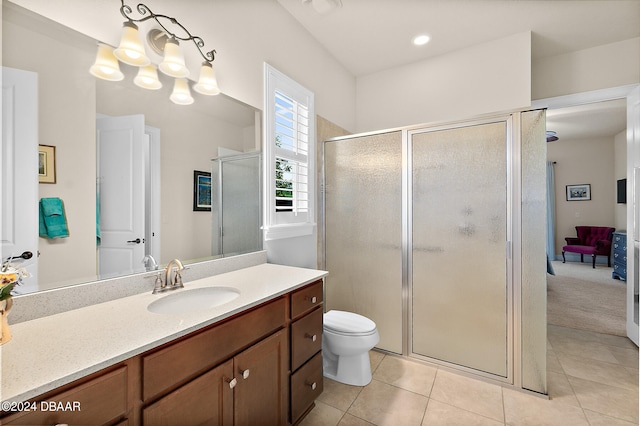 bathroom featuring toilet, an enclosed shower, vanity, and tile patterned flooring