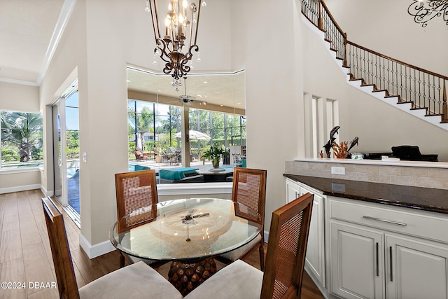 dining area with a wealth of natural light, ornamental molding, and hardwood / wood-style flooring