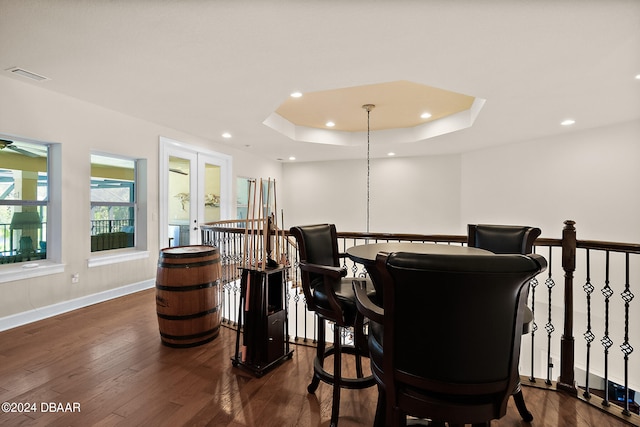 dining area featuring a tray ceiling and dark hardwood / wood-style floors