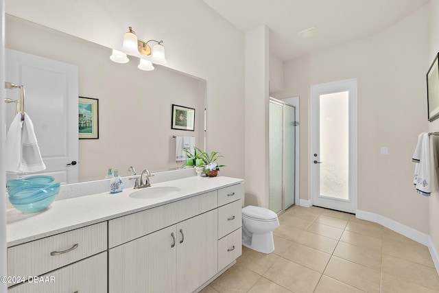 bathroom featuring toilet, an enclosed shower, vanity, and tile patterned flooring