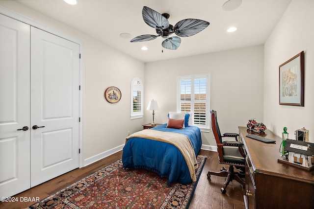 bedroom featuring dark wood-type flooring, a closet, and ceiling fan