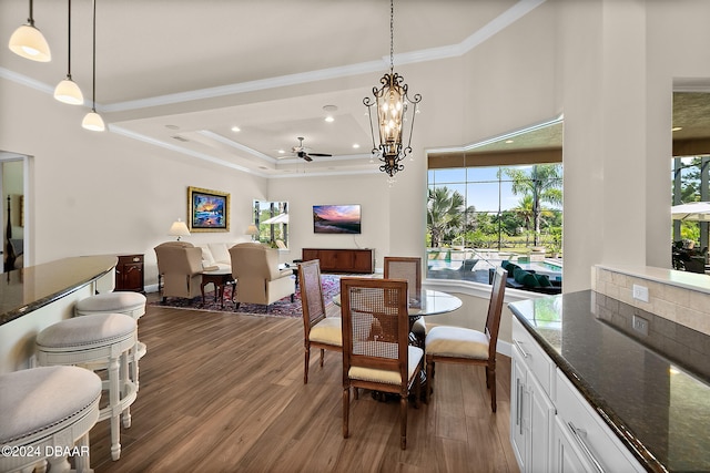 dining room with ceiling fan with notable chandelier, dark hardwood / wood-style floors, and plenty of natural light