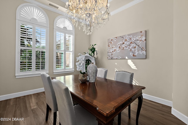 dining area featuring dark hardwood / wood-style floors, an inviting chandelier, and crown molding