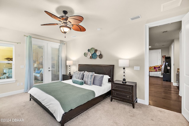 bedroom featuring french doors, black fridge, access to outside, hardwood / wood-style flooring, and ceiling fan