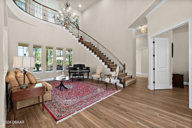 living room featuring a high ceiling, wood-type flooring, and a chandelier