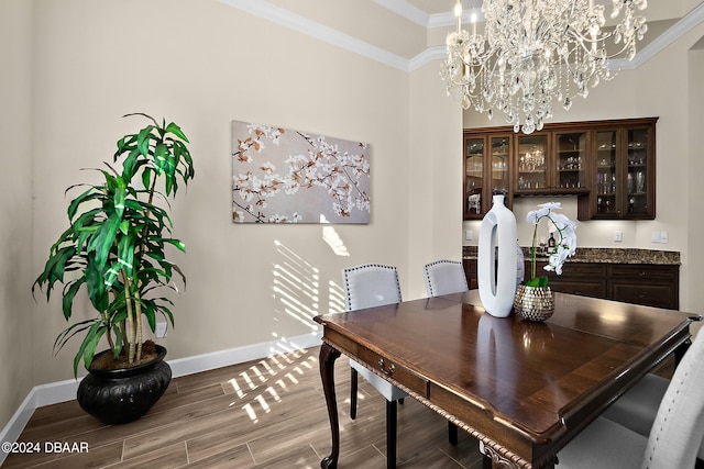 dining room with hardwood / wood-style floors, a notable chandelier, and ornamental molding