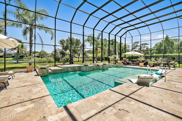 view of pool with a patio area, a lanai, and pool water feature