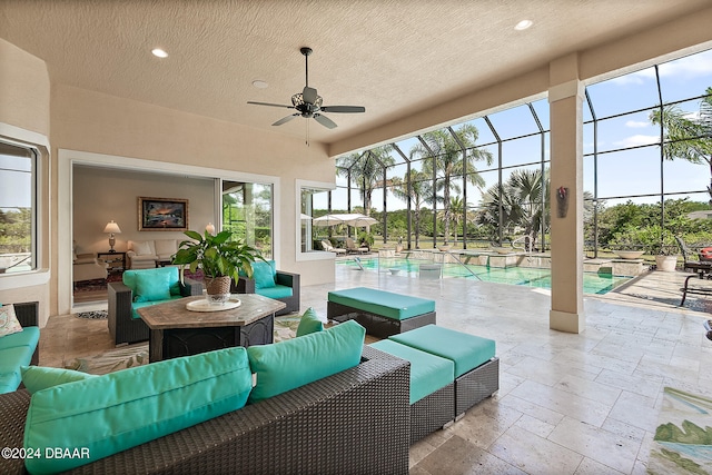 view of patio with glass enclosure, ceiling fan, and an outdoor living space