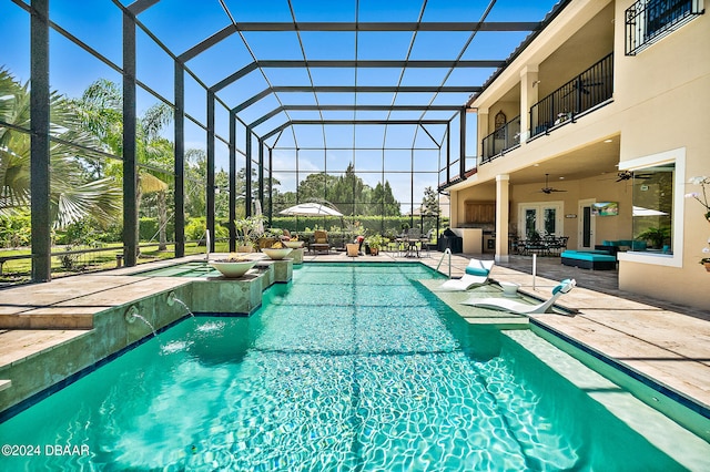 view of swimming pool featuring ceiling fan, a lanai, a hot tub, and a patio area