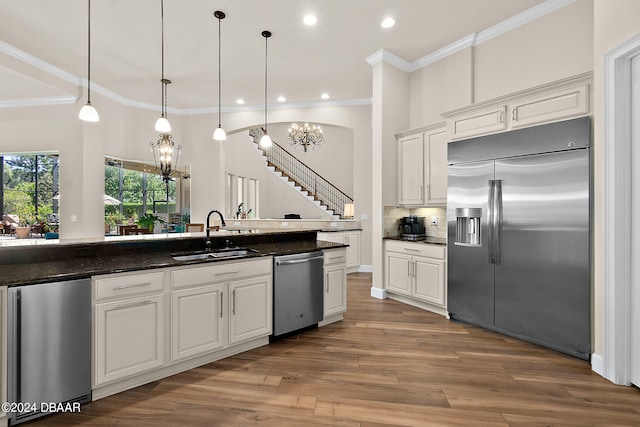 kitchen featuring white cabinetry, appliances with stainless steel finishes, wood-type flooring, and sink