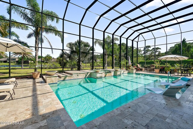 view of swimming pool featuring glass enclosure, a patio area, and an in ground hot tub