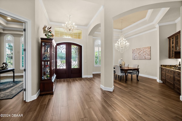 entrance foyer featuring dark hardwood / wood-style flooring, a chandelier, and ornamental molding