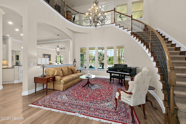 living room with a towering ceiling, light hardwood / wood-style floors, and sink