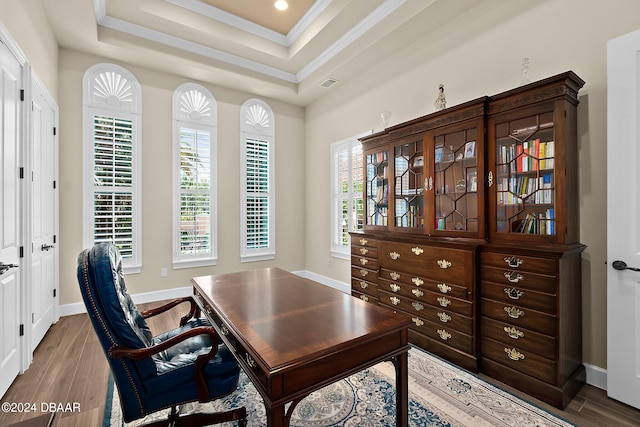 home office featuring hardwood / wood-style flooring, a healthy amount of sunlight, a raised ceiling, and crown molding