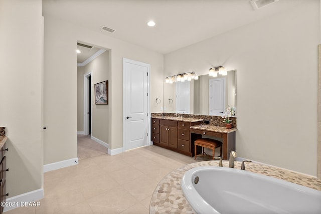 bathroom with ornamental molding, tile patterned flooring, vanity, and tiled tub