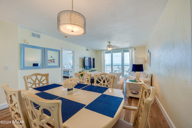 dining space featuring wood-type flooring and ceiling fan