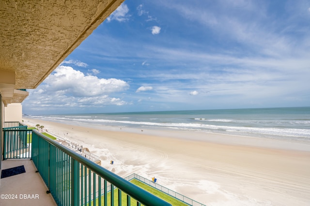 balcony featuring a view of the beach and a water view