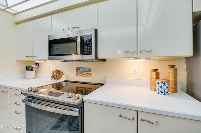 kitchen featuring stainless steel appliances and white cabinetry