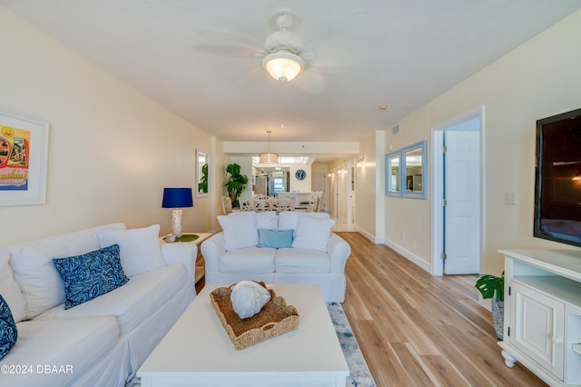 living room featuring ceiling fan and light hardwood / wood-style floors