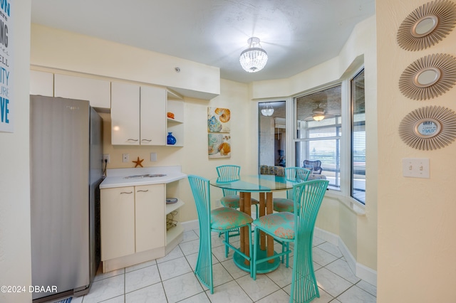 kitchen featuring white cabinets, stainless steel refrigerator, and light tile patterned floors