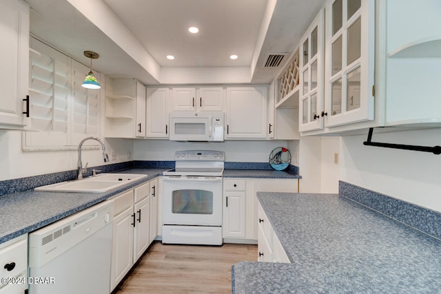 kitchen featuring white cabinets, sink, light wood-type flooring, white appliances, and decorative light fixtures